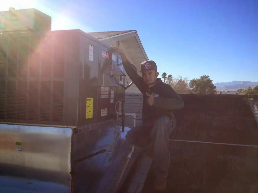 HVAC technician performing Air Duct Repair on a rooftop unit in Baldwinsville
